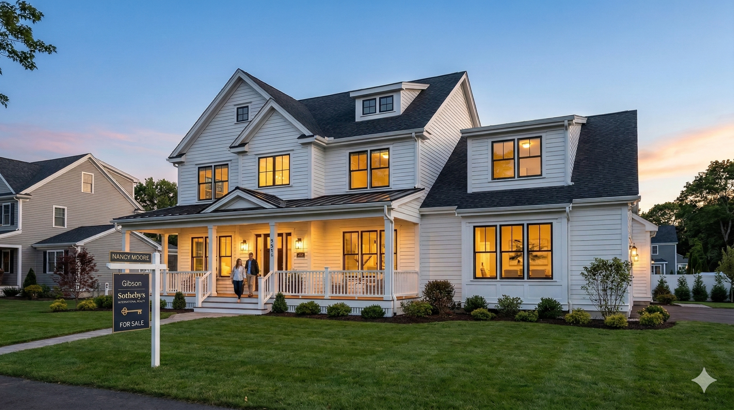 A cinematic wide-angle photograph taken at dusk, showing a charming, modern New England-style luxury home with white siding and a wrap-around porch, listed for sale in a suburban neighborhood of Needham, Massachusetts, in 2026. Warm light spills from within, contrasting with the cool twilight sky. A sleek 'FOR SALE' sign stands on the lawn. A couple is seen walking on the porch. Other similar suburban homes are in the background